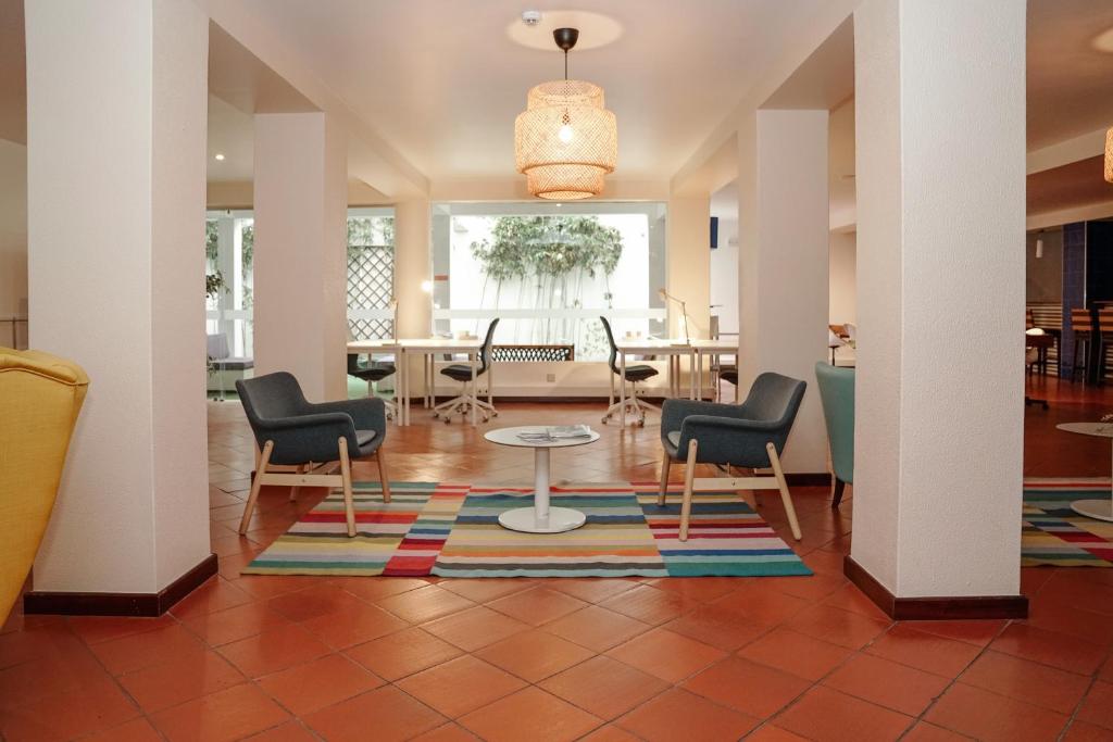 a lobby with chairs and a table and a dining room at Carvi Beach Hotel in Lagos