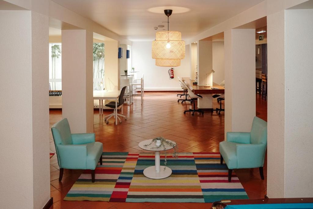 a living room with two chairs and a table on a rug at Carvi Beach Hotel in Lagos
