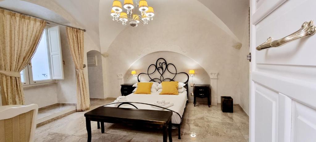 una camera con letto e lampadario a braccio di Palazzo Castiglione a Gallipoli