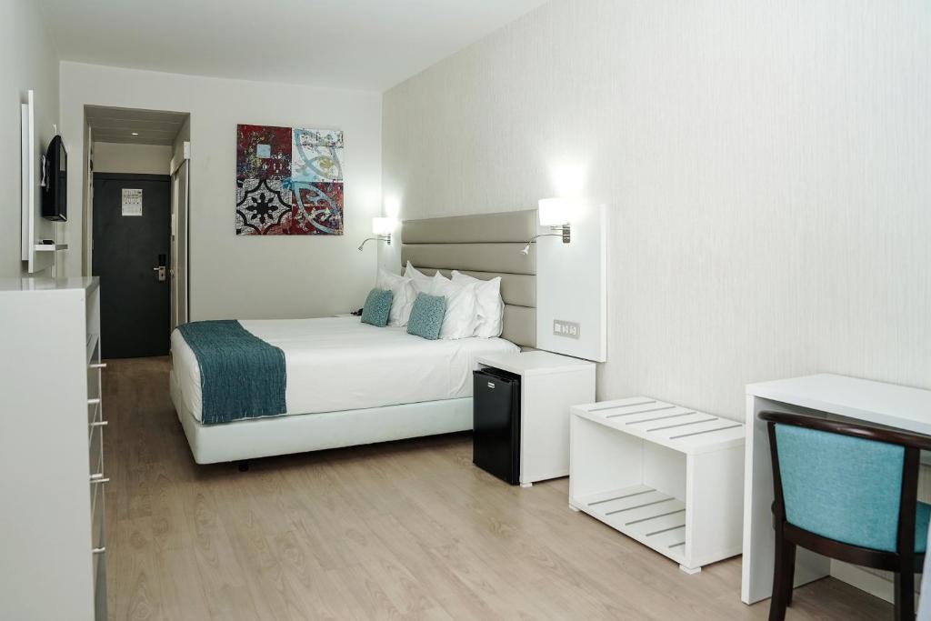 a hotel room with a bed and a table and a chair at Carvi Beach Hotel in Lagos