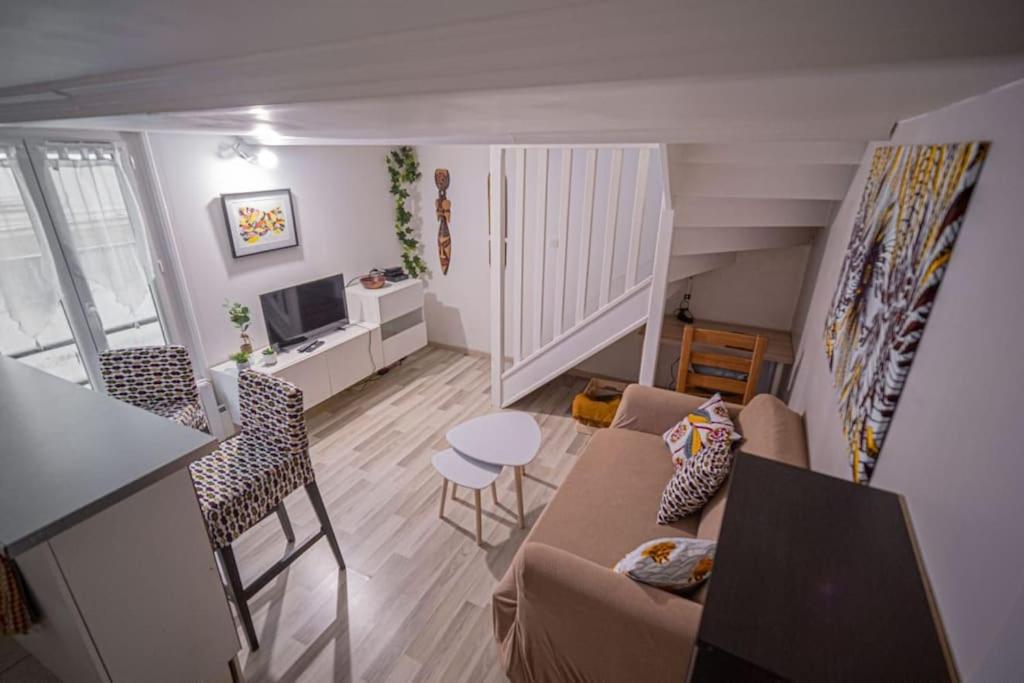 un salon avec un canapé, une table et des chaises dans l'établissement Charmant DUPLEX - centre de Fontainebleau, à Fontainebleau