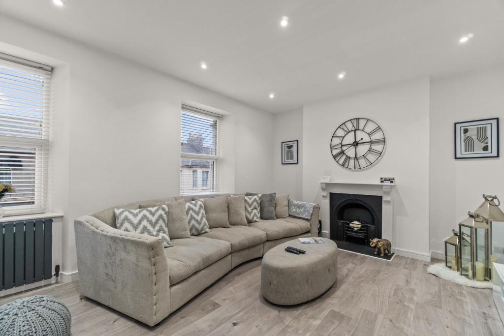 a living room with a couch and a fireplace at The Grenville - Stunning Spacious Central Plymouth Apartment - Sleeps 4 in Plymouth