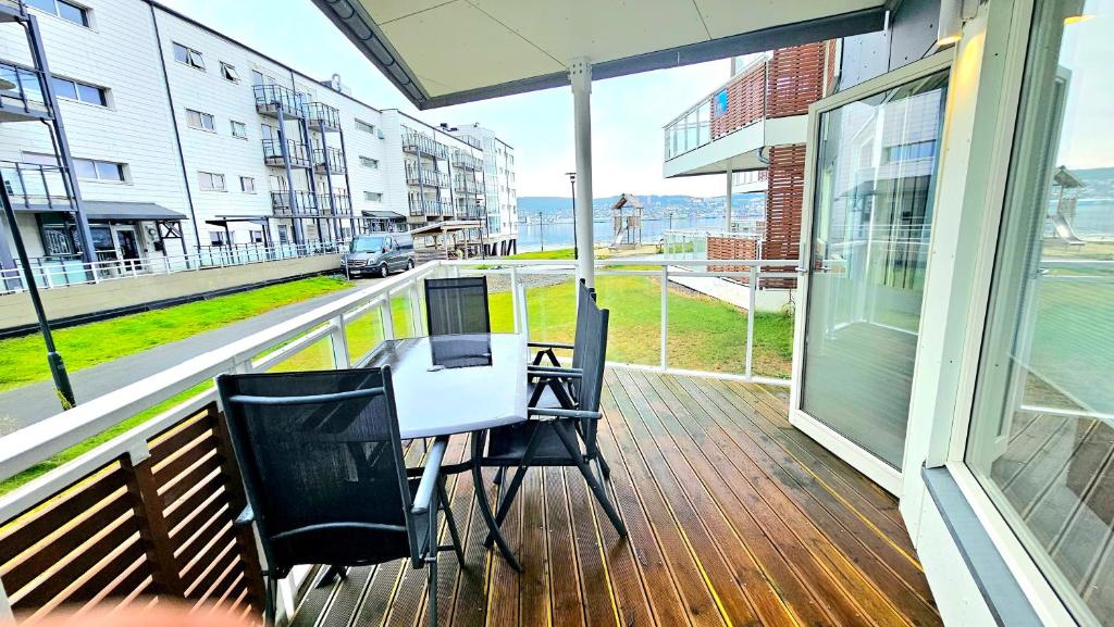 porche con mesa y sillas en el balcón en Very cozy and central appartment near the city centre, en Tromsø