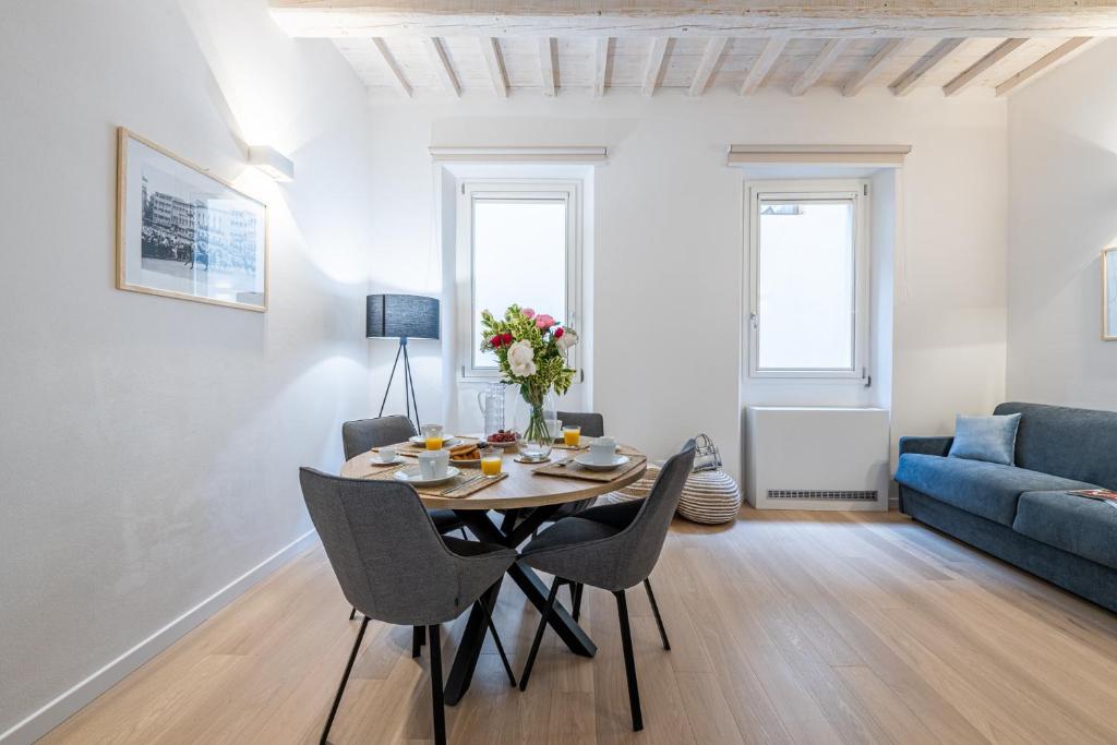 a dining room with a table and chairs and a couch at Fiordaliso Boutique Apartments in Florence