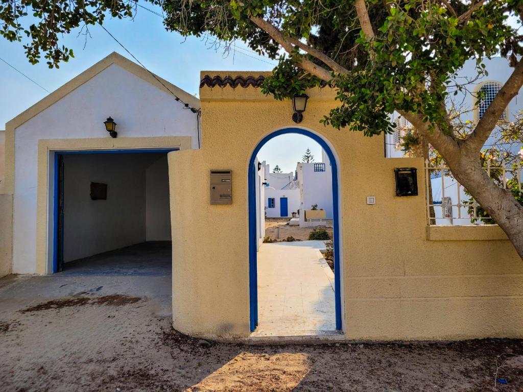 an archway in the side of a building with a garage at Maison Karima in Djerba