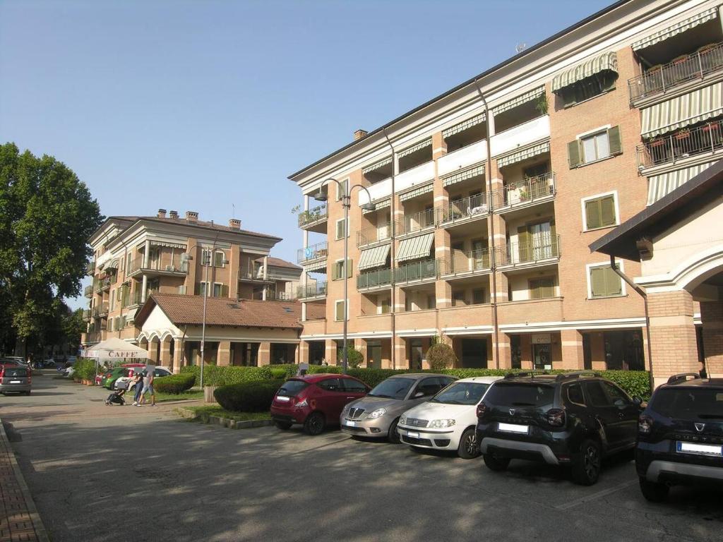 ein Parkplatz mit Autos vor einem Gebäude in der Unterkunft Appartamento signorile in Orbassano