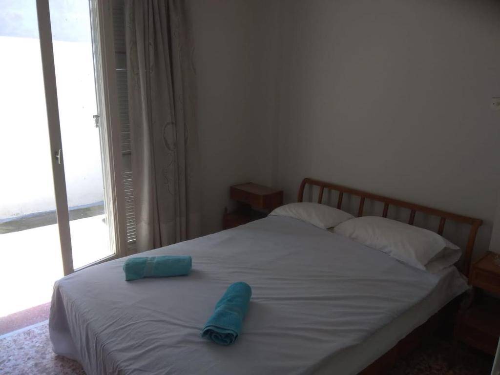 a bed with a blue pillow on top of it at Lemon Apartment near to Pireaus Port in Piraeus