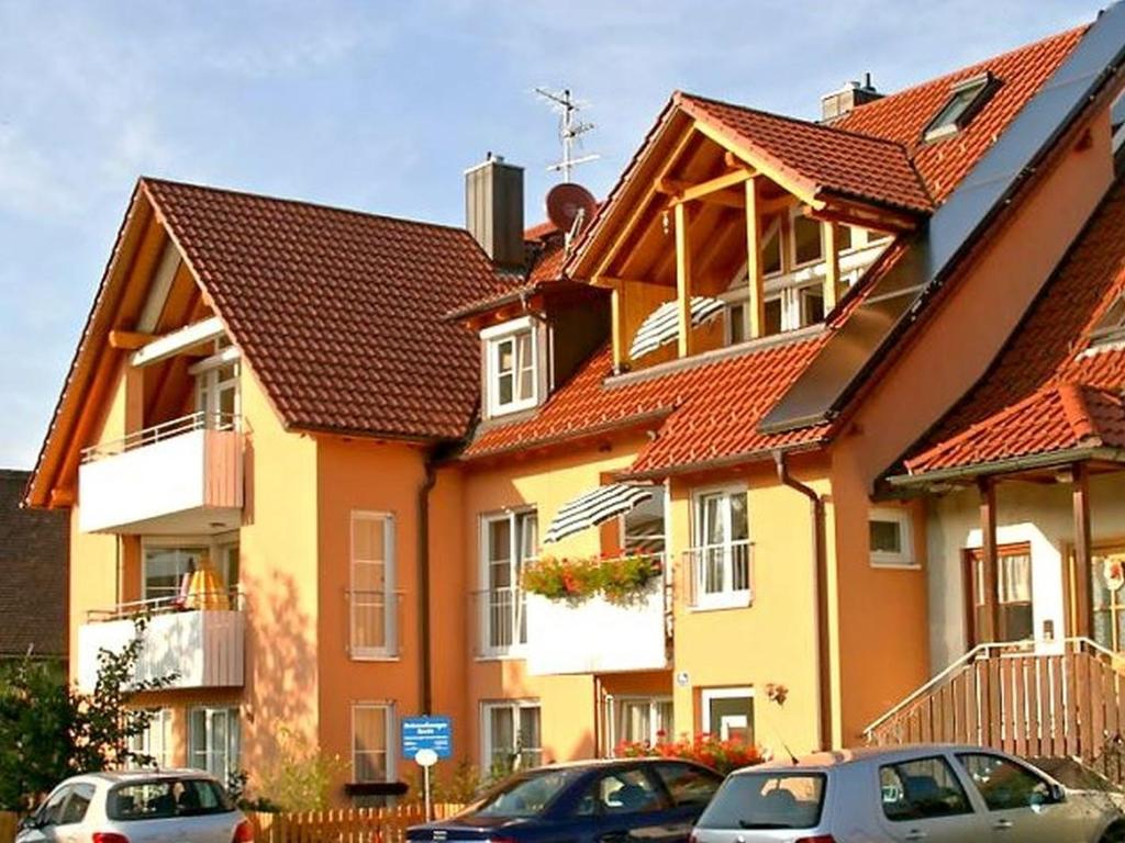 una grande casa con macchine parcheggiate di fronte di Ferienwohnungen Shamal a Reutin