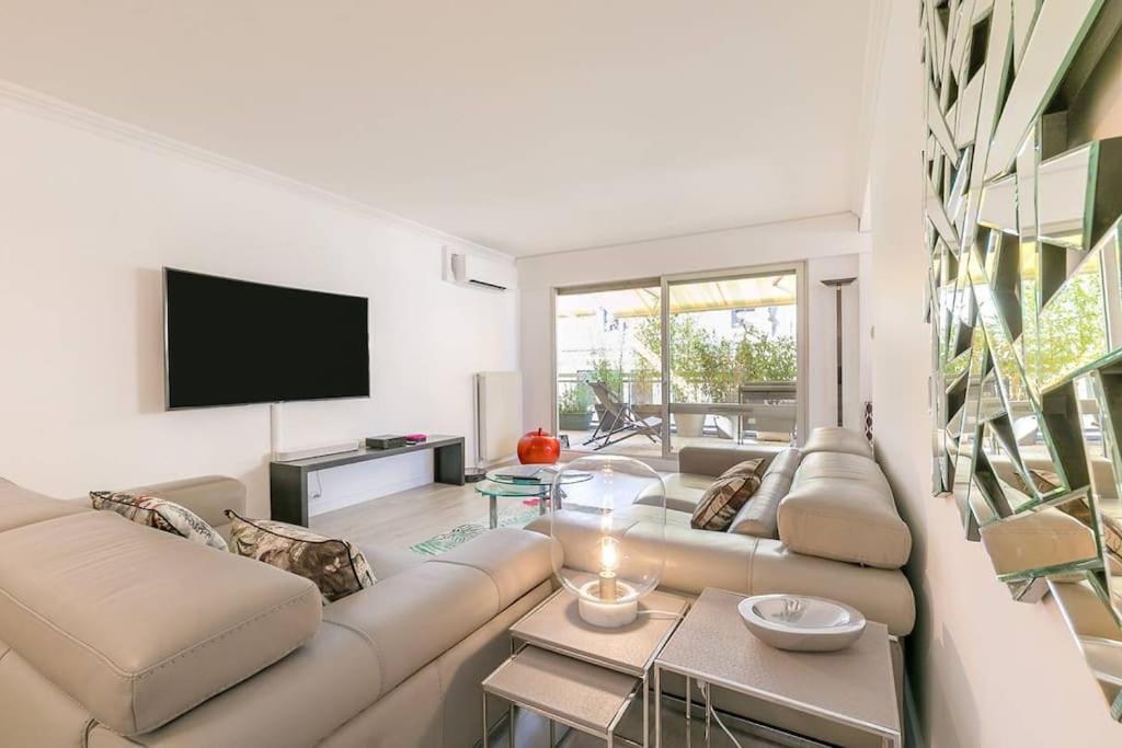 un salon avec un canapé et une télévision dans l'établissement Les Bambous, à Dijon