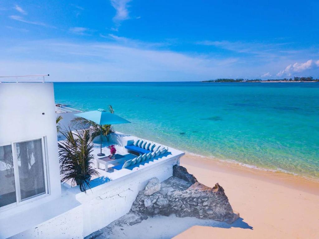 a house on the beach with a view of the ocean at Modern, Stunning Bright Central Beach Villa in Nassau