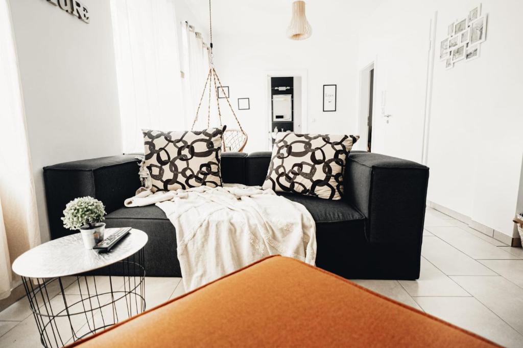 a living room with a black couch and a table at Holiday Home Leonie in Bollendorf