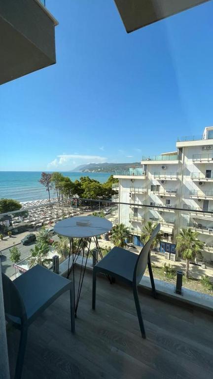 einen Balkon mit einem Tisch und Stühlen sowie ein Gebäude in der Unterkunft Sole apartments in Shëngjin