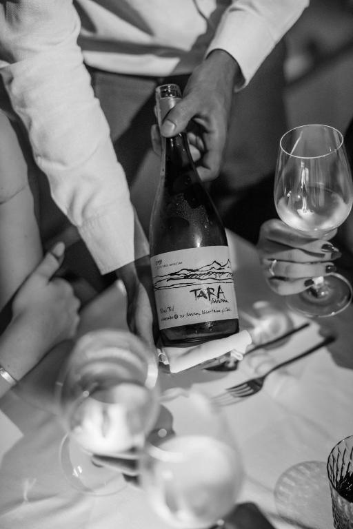 a group of people standing around a table with a bottle of wine at 7Pines Resort Ibiza, part of Destination by Hyatt in San Jose