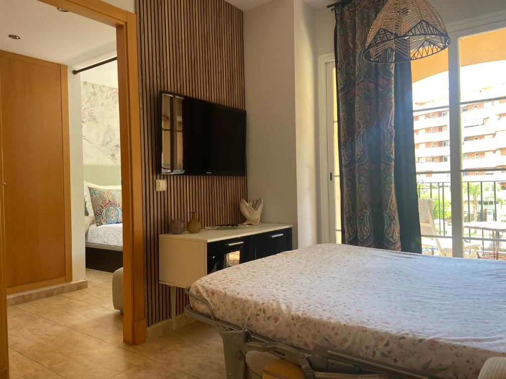 - une chambre avec un lit et une télévision à écran plat dans l'établissement Apartamento Julieta, à Estepona