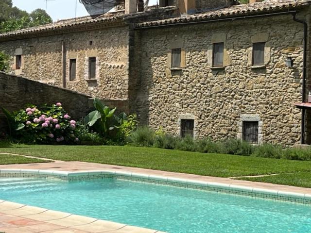 Foixá的住宿－CAL CARRETER，石头建筑前的游泳池