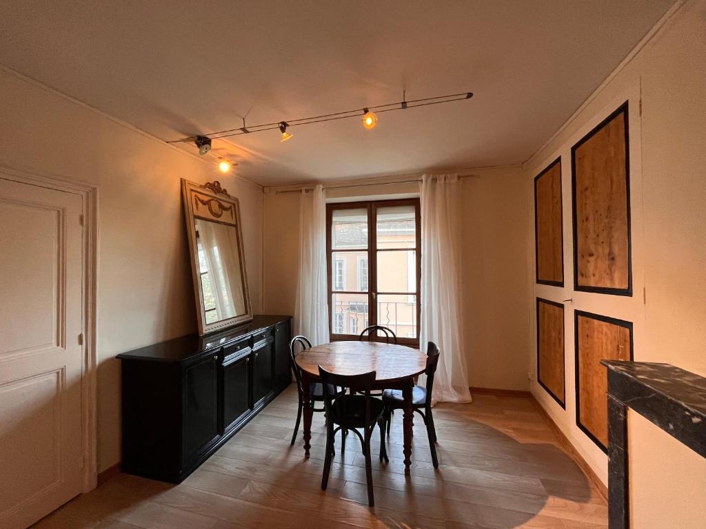 d'une salle à manger avec une table, des chaises et une fenêtre. dans l'établissement Charmant appartement 2 pièces au Centre ville, à Grenoble