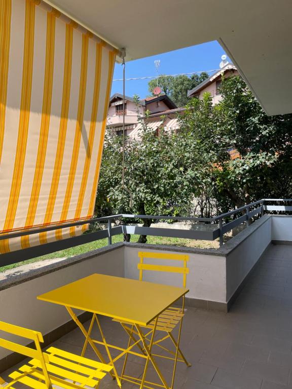 Ronago的住宿－B&B FIOR DI CAMPO，阳台的黄色桌椅