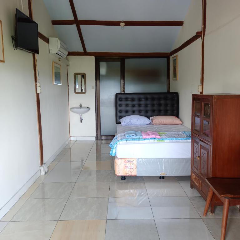 Postel nebo postele na pokoji v ubytování Omah Singo Stay & Resto Yogyakarta