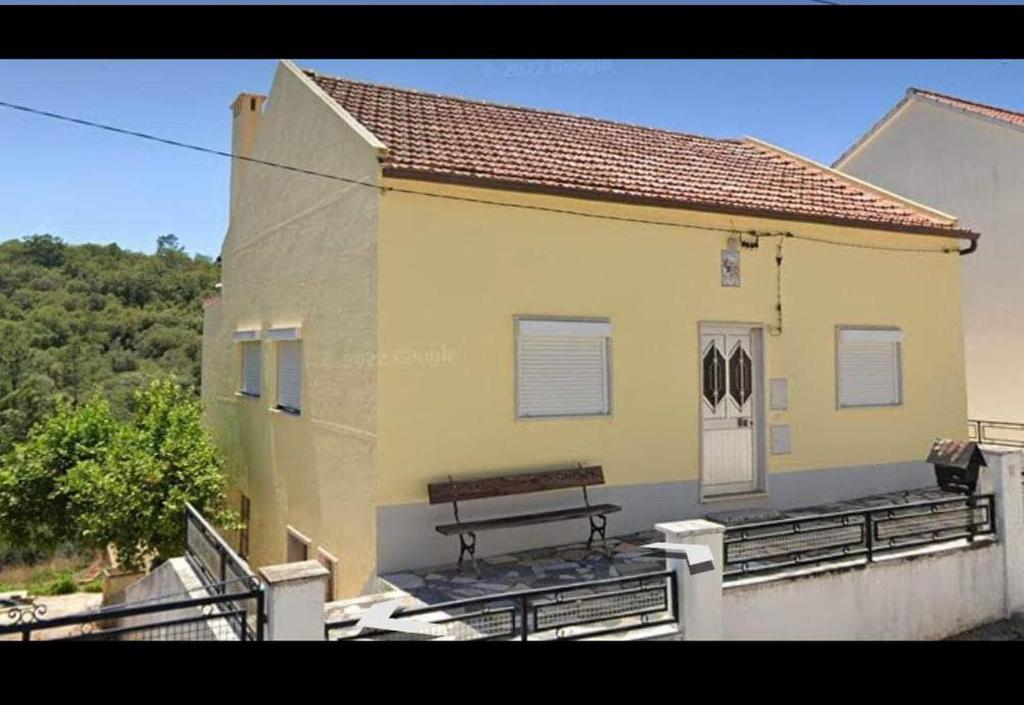 un banco en el balcón de un edificio amarillo en Gîte Manubelle, 