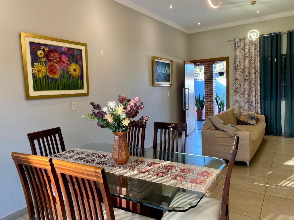 a dining room and living room with a table and chairs at Agradable casa independiente con jardín y estacionamiento in Ciudad del Este