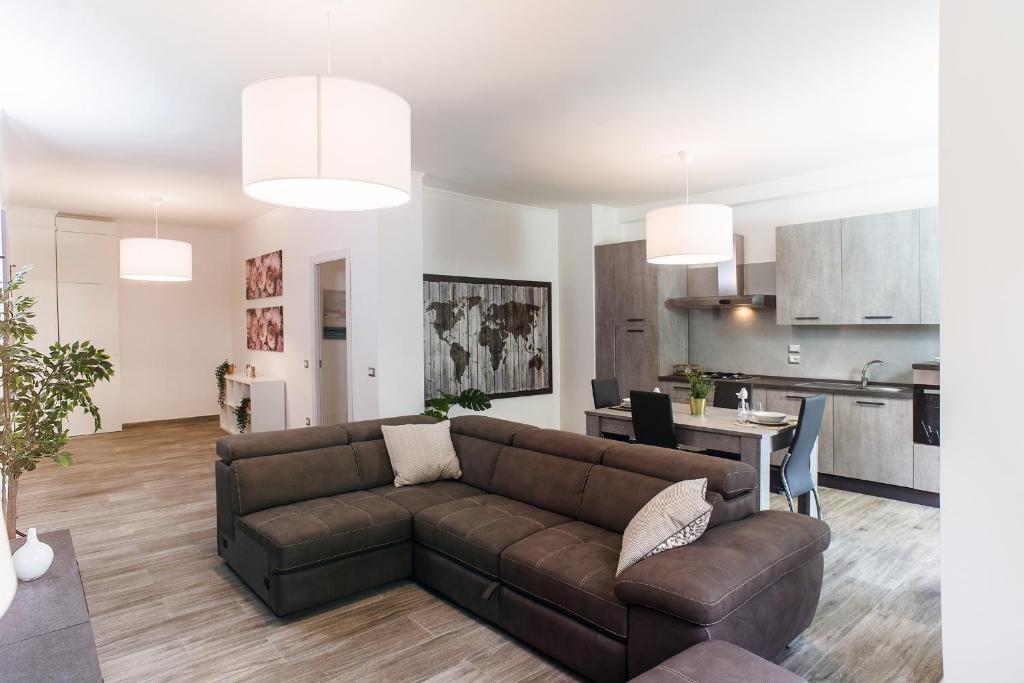 a living room with a brown couch and a kitchen at Residenza Flegrea in Naples