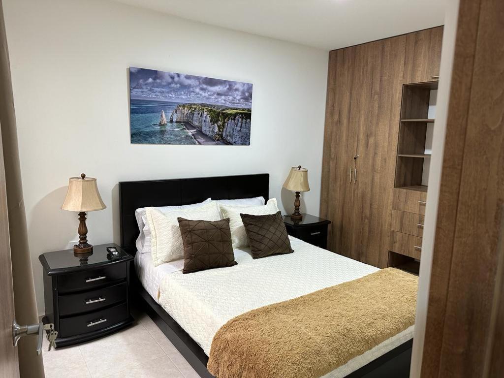 ein Schlafzimmer mit einem Bett und einem Wandgemälde in der Unterkunft Apto-Parking cerca CC Gran Plaza in Pitalito