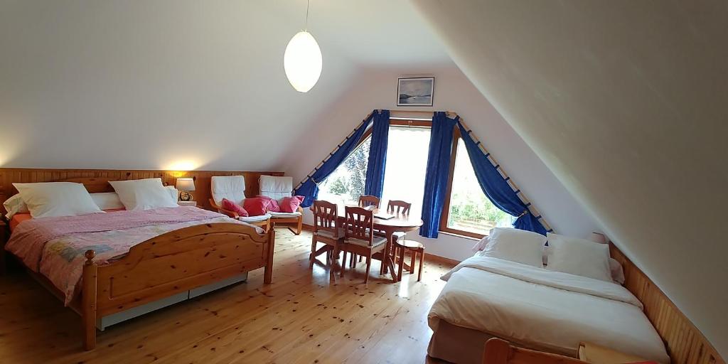 een slaapkamer op zolder met 2 bedden en een raam bij Le Clos des Marais de Fontenay in Fontenay-le-Vicomte