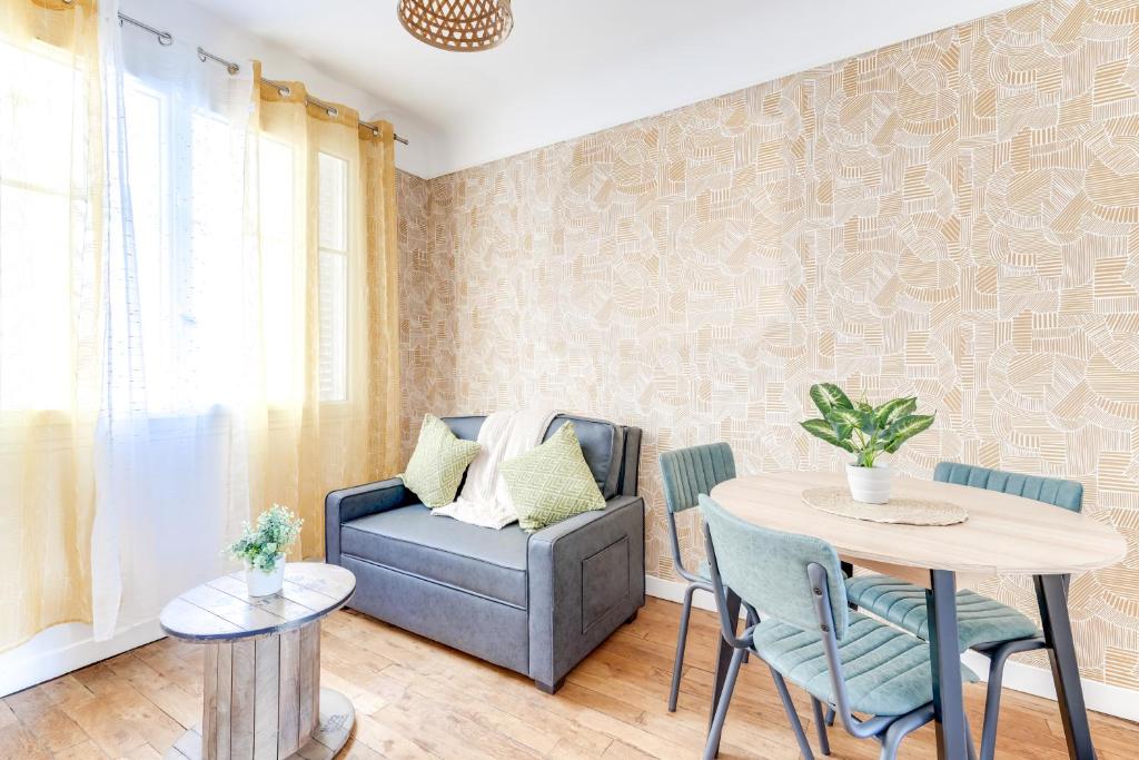 een woonkamer met een stoel en een tafel bij Chic apart Paris - La defense in Courbevoie