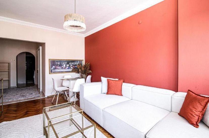 - un salon avec un canapé blanc et un mur rouge dans l'établissement Luxury and comfortable flat in Ortakoy, à Istanbul