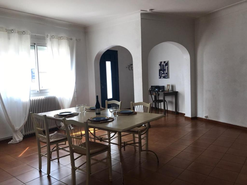 een eetkamer met een houten tafel en stoelen bij La casa Marcel, maison de 110 m2 in Pia