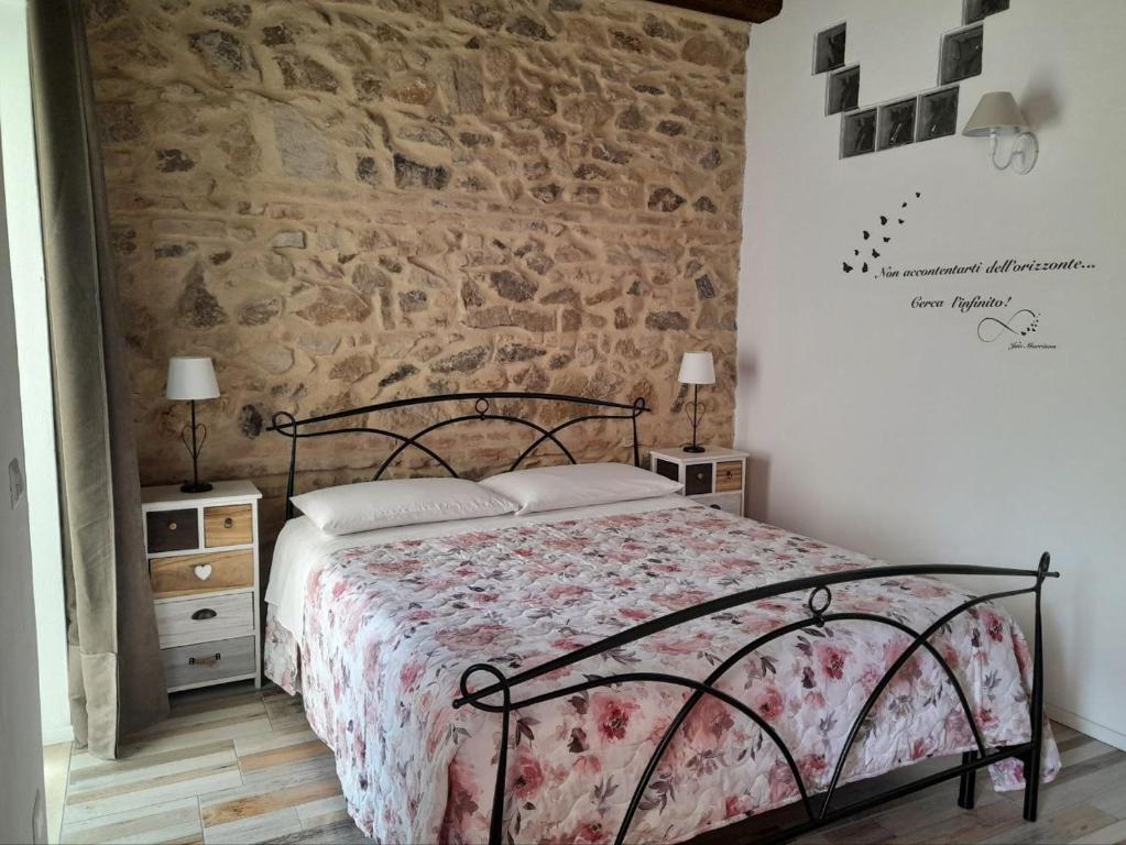 - une chambre avec un lit et un mur en pierre dans l'établissement Appartamenti Monte Selce, à Monselice