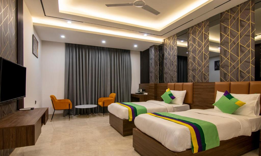 Habitación de hotel con 2 camas y TV de pantalla plana. en Treebo Trend The Armani Near IGI Airport en Nueva Delhi