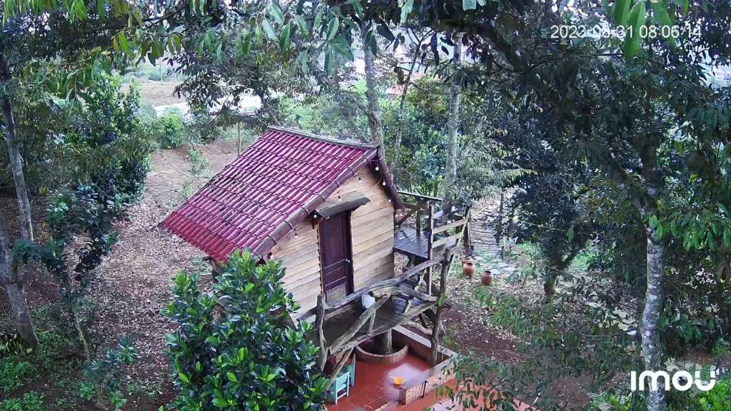 uma pequena casa com um telhado vermelho na floresta em Mộc Hương farmstay 