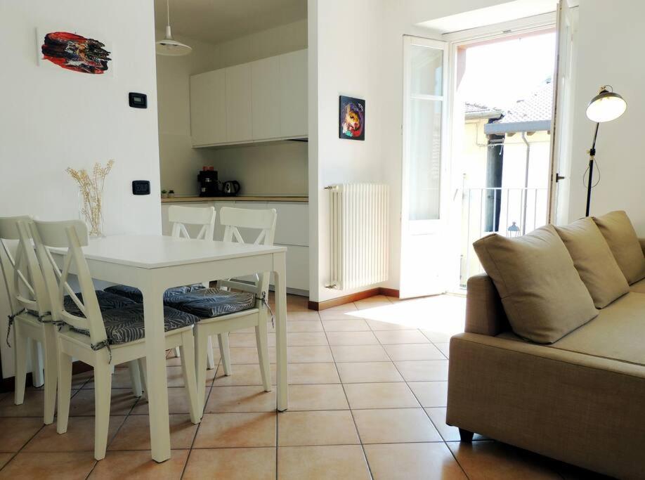 uma sala de estar com uma mesa branca e cadeiras em La piazza al lago - A 40 metri dal lago em Mandello del Lario