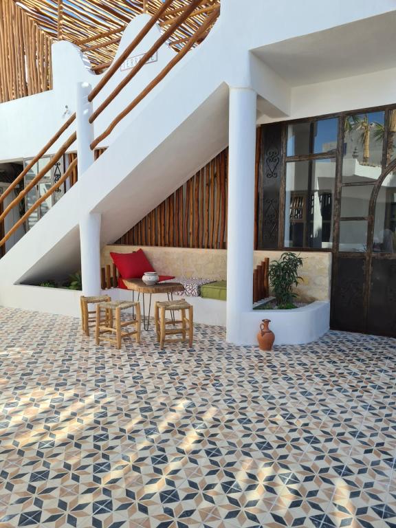 an outdoor patio with a table and chairs and stairs at La Maison des Vagues in Sidi Kaouki