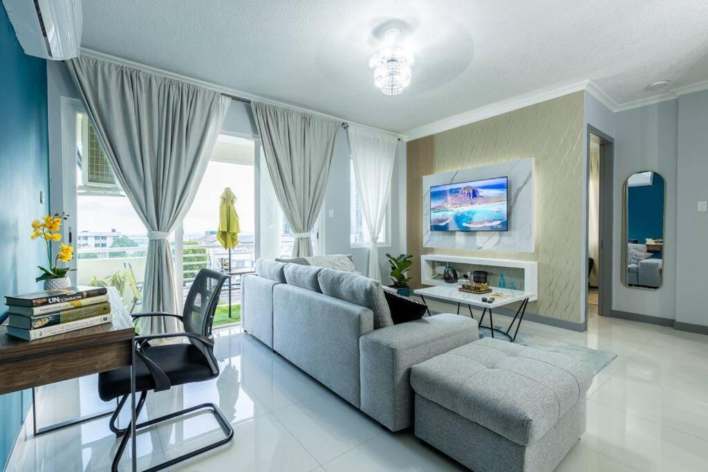 a living room with a couch and a table at Modern Luxury Apartment in New Kingston in Kingston