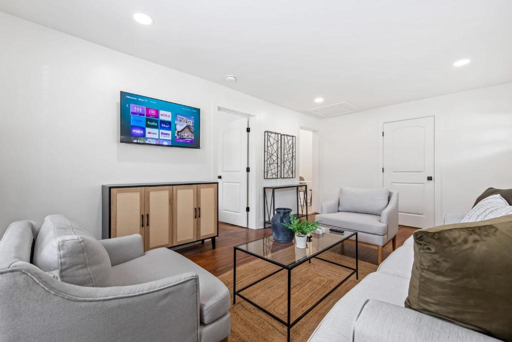 a living room with two couches and a tv at Saints Street Charmer in Lafayette