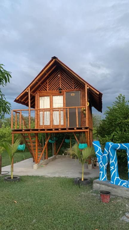 a tree house with a balcony in a yard at Hotel la Isla campestre in Villavieja