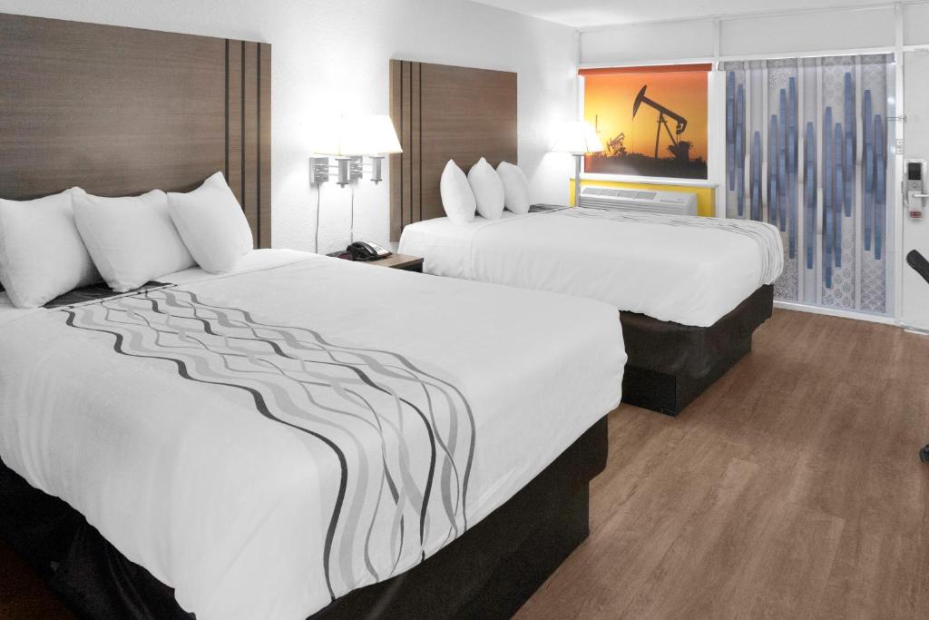 2 camas en una habitación de hotel con sábanas blancas en Econo Lodge, en Carlsbad