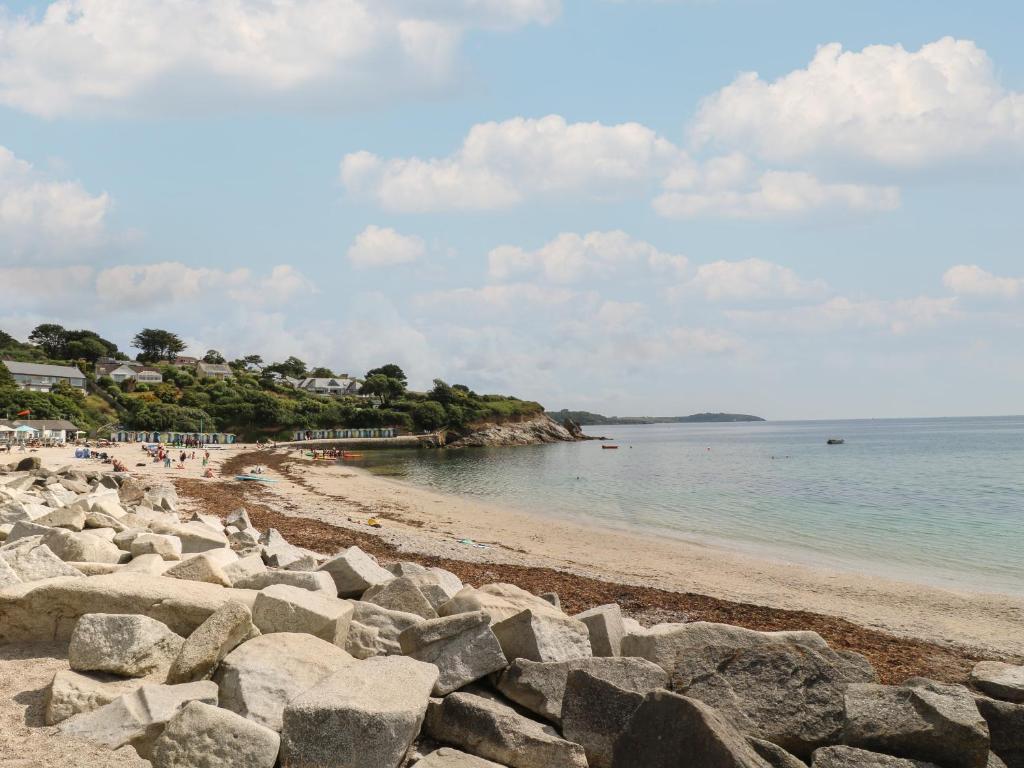 a beach with rocks and people on the water at Pugwash Cottage in Falmouth