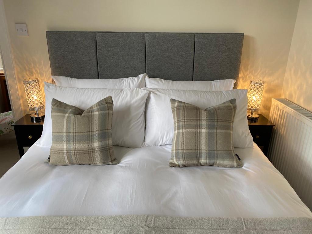 a white bed with two pillows and a headboard at Tranquil Haven Murrayfield in Edinburgh