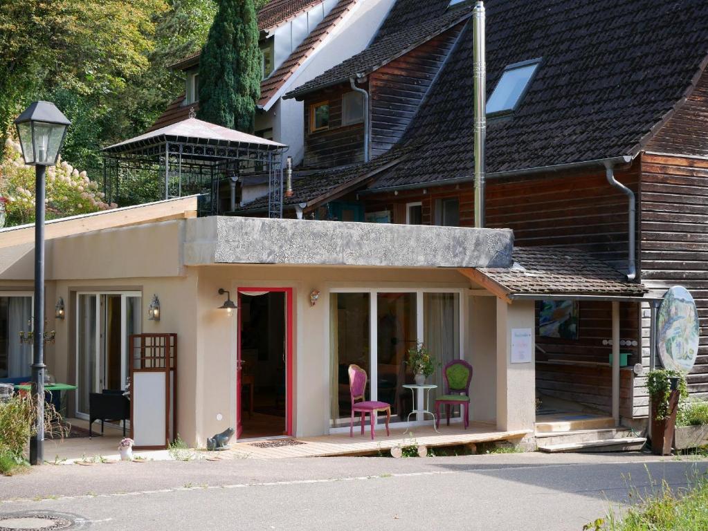 una piccola casa con una porta rossa e un edificio di Haus Der Malerin Andrea Gawaz a Müllheim