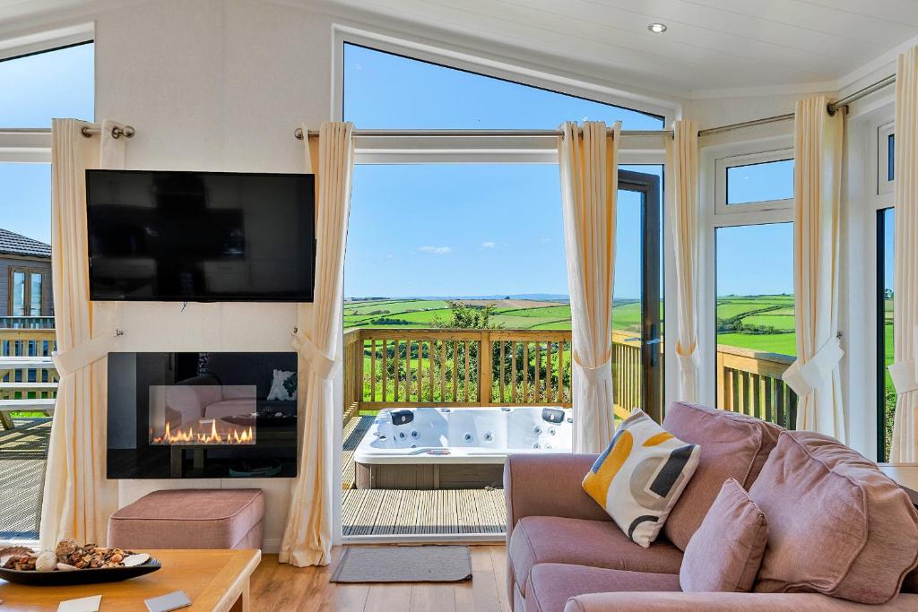 a living room with a fireplace and a large window at Finest Retreats - Seacroft in Torpoint