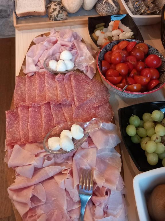einen Tisch mit Fleisch und Gemüse und Schalen von Tomaten in der Unterkunft Albergo ai Sapori in San Daniele del Friuli