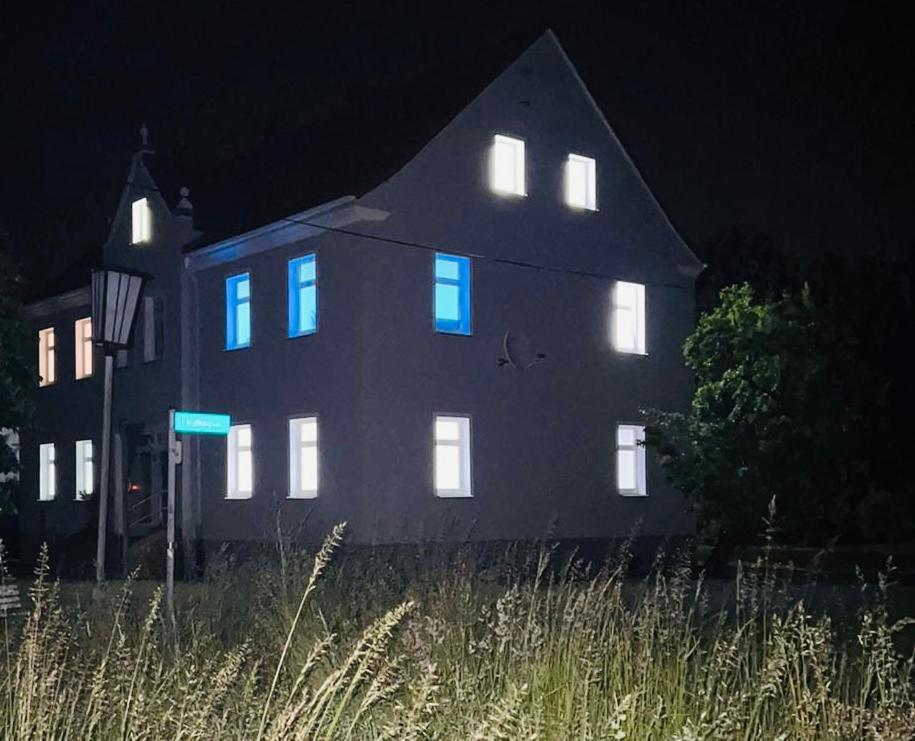 Una casa con luces azules en el costado. en Berzi Ferienwohnung 001 Görlitz, en Markersdorf
