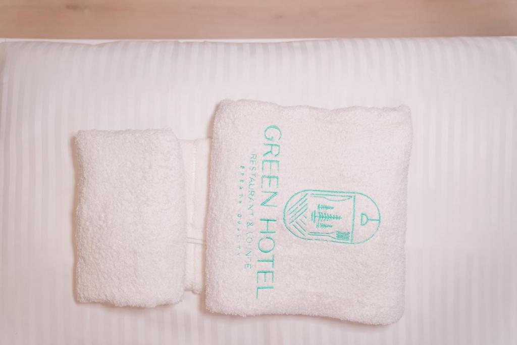 two towels are sitting on a bed next to each other at Green Apartments Prishtina in Pristina