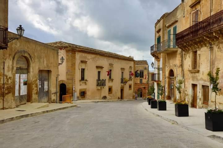 una calle vacía en un viejo pueblo con edificios en Rinaldo Holiday Home, en Sambuca di Sicilia