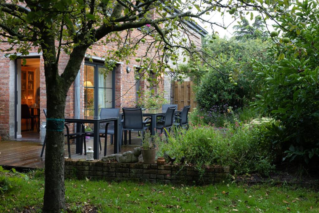 un patio con mesa y sillas en un jardín en B&B Destiny, en Maldegem