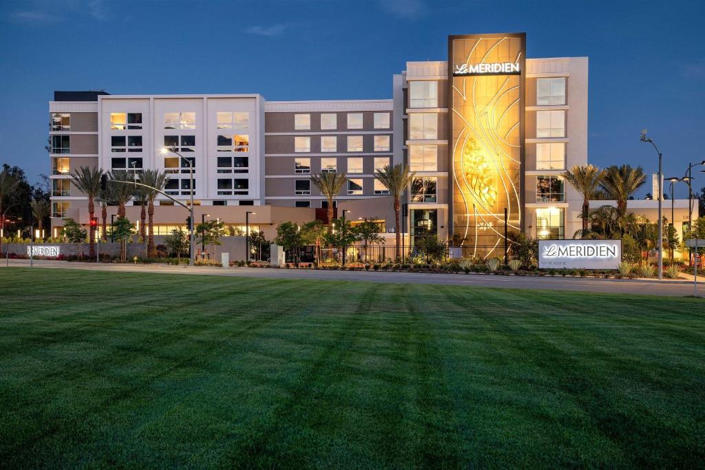 a large building with a grass field in front of it at Le Méridien Pasadena Arcadia in Arcadia