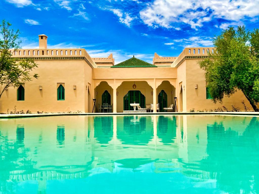 a house with a pool in front of it at Villa Riadi in Marrakech in Marrakesh